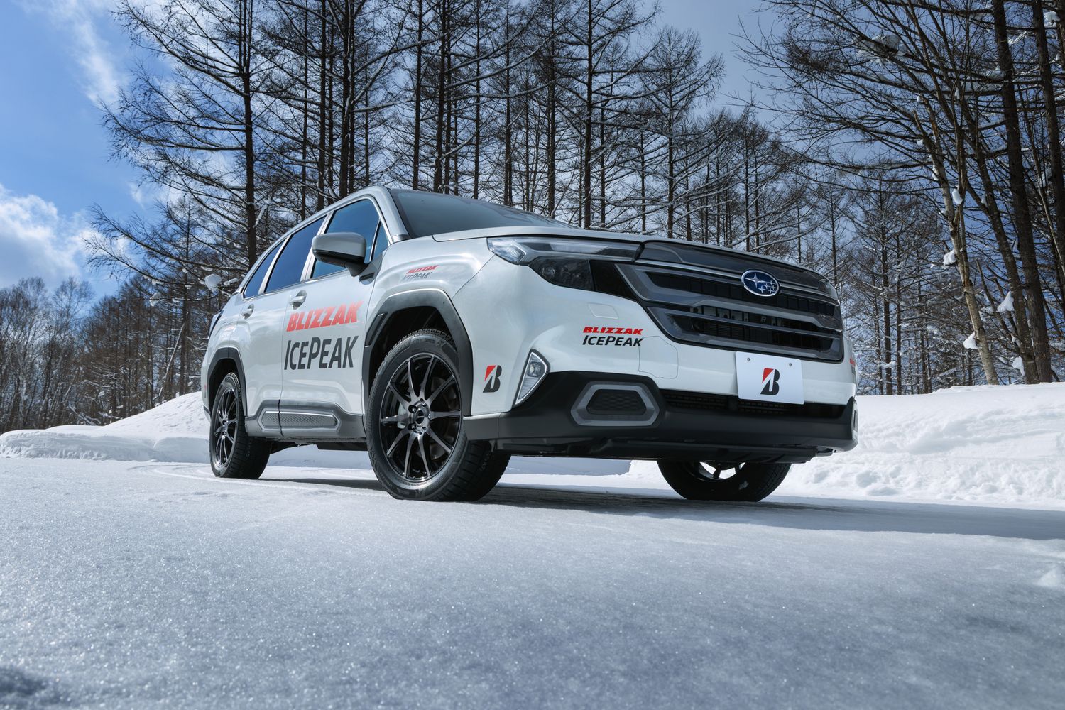 雪の林の前に停まるブリザック アイスピークのテスト車両